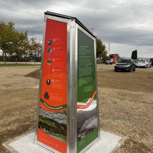 Deux faces d’une borne patrimoniale : panneau rouge avec codes QR et panneau vert sur le territoire de Petite-Rivière-Saint-François.